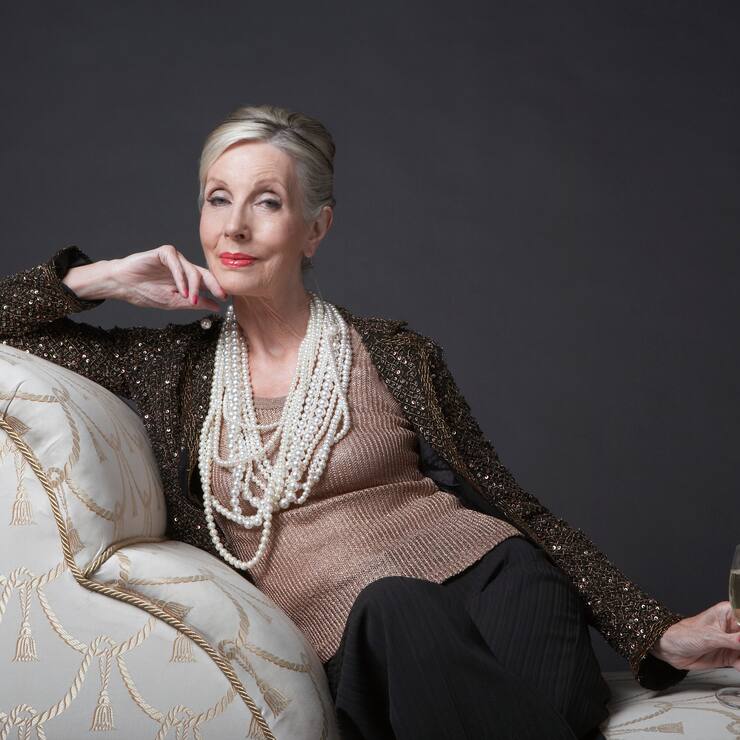 Reichtum Vermögen Perlenkette Champagner Frau Sofa