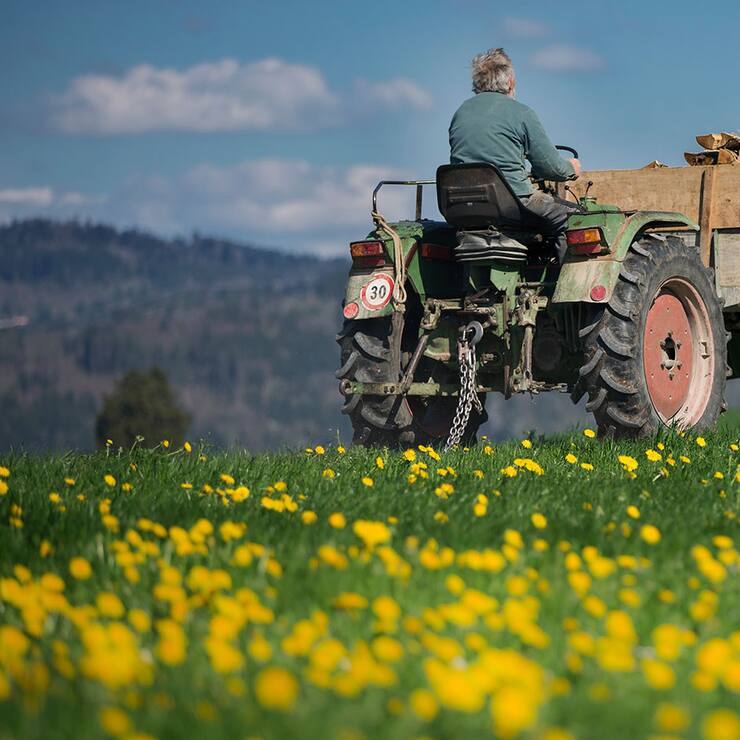 Bauer mit Traktor auf Wiese