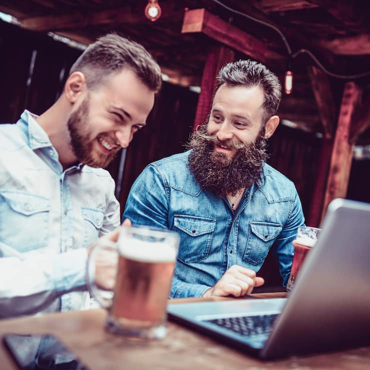 Freelancing Businessmen Drinking Beer And Working Together In A Bar