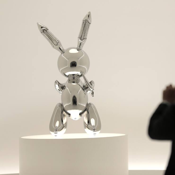 A man takes a picture of a sculpture entitled "Rabbit" by Jeff Koons during a media preview at Christie's in New York, Friday, May 3, 2019. This sculpture along with other artworks will be sold in series of auctions starting on May 13, 2019. (AP Photo/Seth Wenig)
