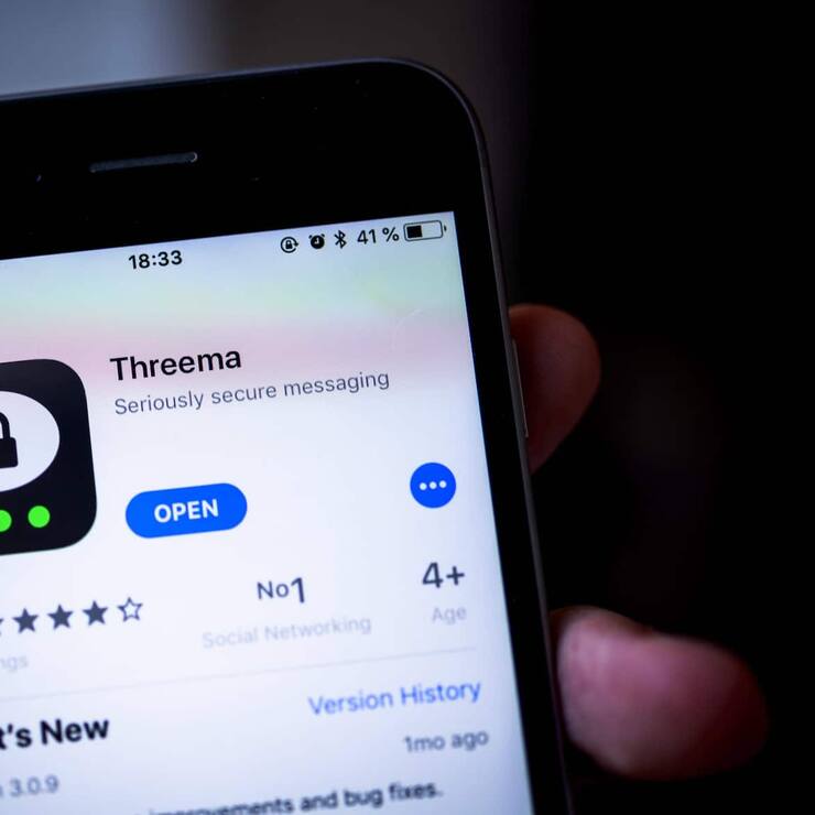 Hand hält iPhone mit Threema, sichere Instant Messenger App, im Apple App Store, App-Icon, Display, iPhone, iOS, Smartphone, Deutschland, Europa