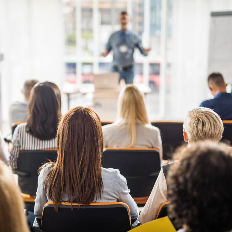 Back view of large group of business people having a training class in a board room.