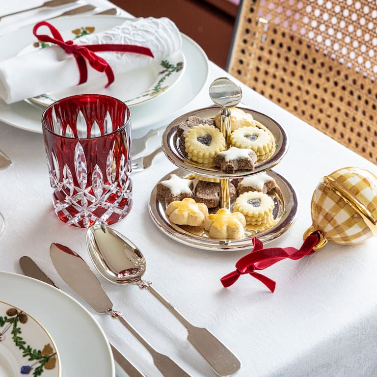 Tafelrunde Weihnachten mit Silberbesteck, rotem Glas und Etagere mit Weihnachtsguetzli.