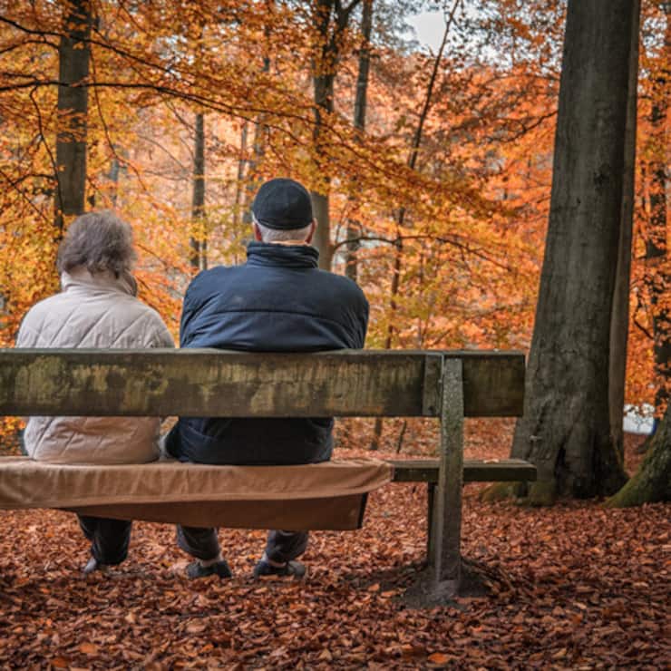 Ein älteres Ehepaar geniesst die Ruhe im Wald.