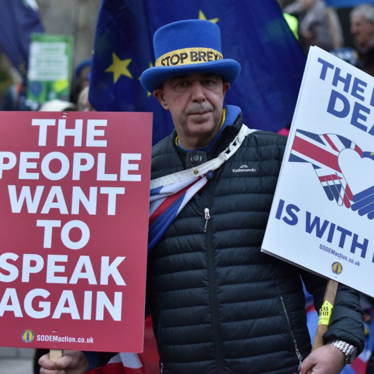 An anti Brexit protester holds placard saying "The people want to speak again and The best deal is with the EU" outside the Houses of Parliament 