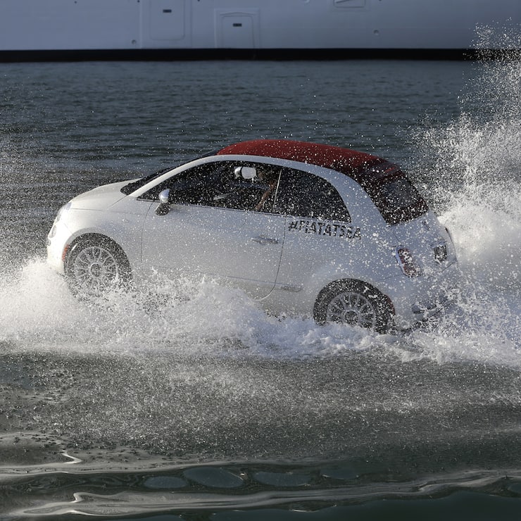 A Fiat 500 watercraft goes through the water as it escorts the MSC Divina cruise ship arrives at the Port of Miami, Tuesday, Nov. 19, 2013, in Miami. This is the ship's North American debut since departing Venice, Italy Nov. 2. The Divina will offer year-round Caribbean sailings from its home port of Miami. (AP Photo/Lynne Sladky)