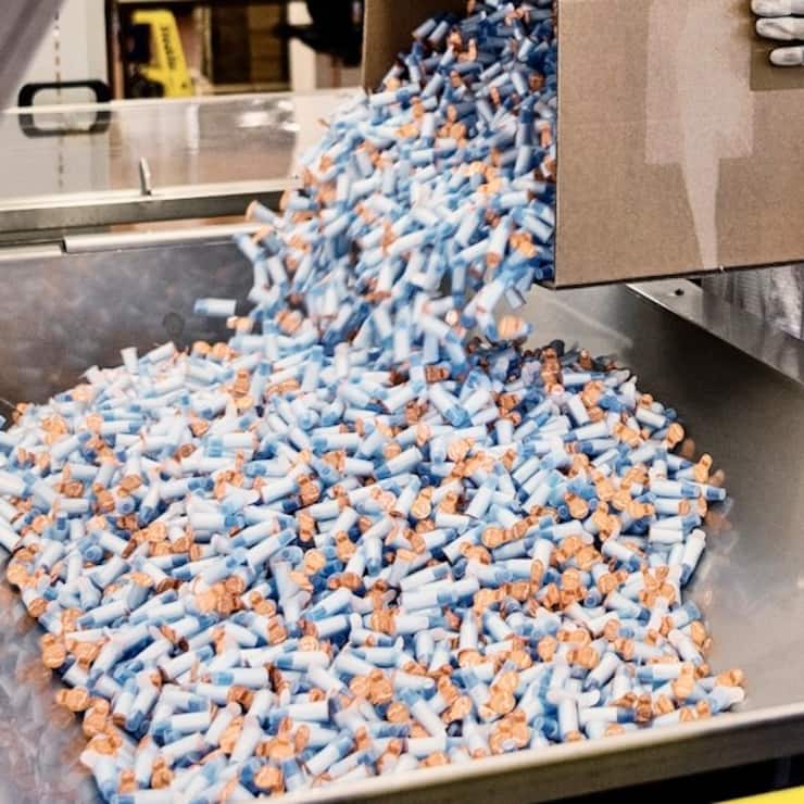 An employee of the medical technology company Ypsomed fills assembled safety pen needles into a packaging machine, pictured at the Ypsomed production site in Burgdorf, Canton of Berne, Switzerland, on August 10, 2018. Ypsomed develops and manufactures injection systems for self-medication. (KEYSTONE/Christian Beutler)