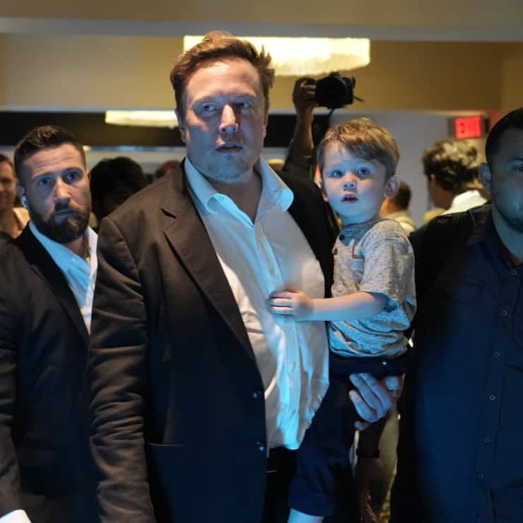 Twitter CEO Elon Musk, center, carries his child as he leaves after speaking at the POSSIBLE marketing conference, Tuesday, April 18, 2023, in Miami Beach, Fla. (AP Photo/Rebecca Blackwell)