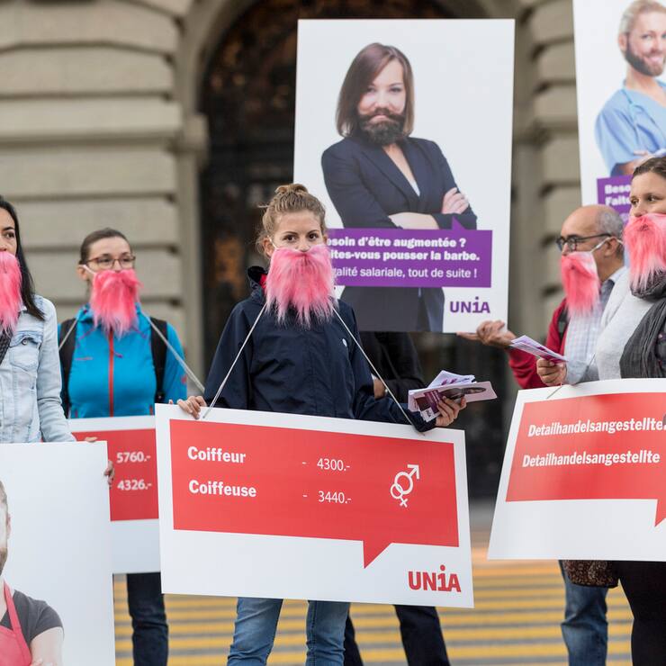 Aktivistinnen der Gewerkschaft UNIA haben sich symbolisch rosa Bärte angeklebt, um ihrer Forderung nach Lohngleichheit zwischen den Geschlechtern Nachdruck zu verleihen, am Rand der Herbstsession der Eidgenössischen Räte, am Dienstag, 11. September 2018 vor dem Bundeshaus in Bern. (KEYSTONE/Alessandro della Valle)