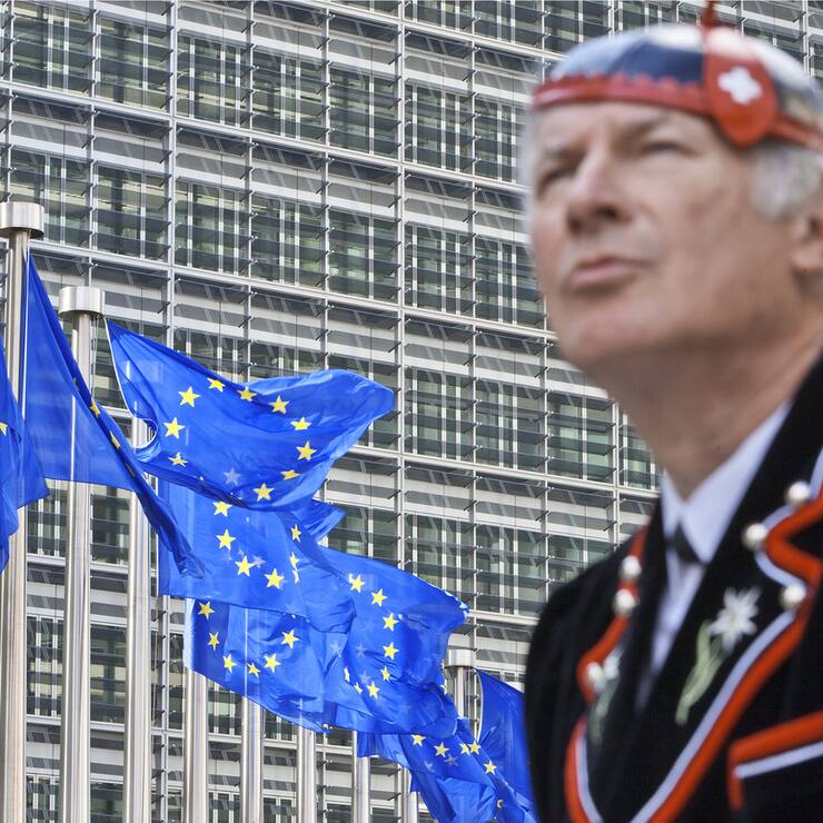 Flags of the European Union wave in front of the European Commission building in Brussels, June 8, 2011, while "Mister Swiss", dressed in a traditional Swiss costume, looks on. He is on his way to visit the heart of Europe or at least the city which hosts the headquarters of the European Union. (KEYSTONE/Martin Ruetschi) *** EDITORS NOTE: Posed picture to illustrate Switzerland within Europe. / Gestellte Aufnahme zum Thema Schweiz und Europa. ***