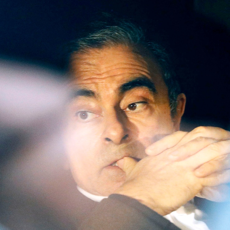 In this March 6, 2019, photo, former Nissan chairman Carlos Ghosn rides in a car from a building in Tokyo. Ghosn, the star auto executive credited with rescuing both Renault and Nissan, left a drab Tokyo detention center Wednesday after more than three months in custody, his identity obscured by a surgical mask, hat, and construction worker's outfit.(Takuya Inaba/Kyodo News via AP, File)
