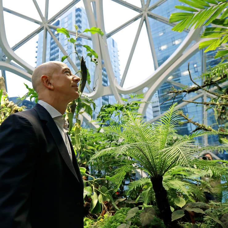 Jeff Bezos, the CEO and founder of Amazon.com, takes a walking tour of the Amazon Spheres, three plant-filed geodesic domes that serve as a work- and gathering place for Amazon employees, following a grand opening ceremony, Monday, Jan. 29, 2018, in Seattle. (AP Photo/Ted S. Warren)