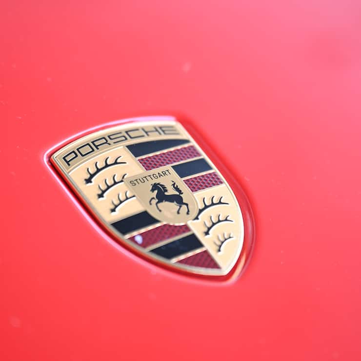 18.07.2025, Baden-Württemberg, Stuttgart: Das Logo von Porsche ist an der Motorhaube eines Porsches angebracht. Porsche-Vorstandschef Blume hat die Beschäftigten des Sportwagenbauers auf eine weitere harte Sparrunde eingestimmt. Foto: Bernd Weißbrod/dpa +++ dpa-Bildfunk +++ (KEYSTONE/DPA/Bernd Weißbrod)