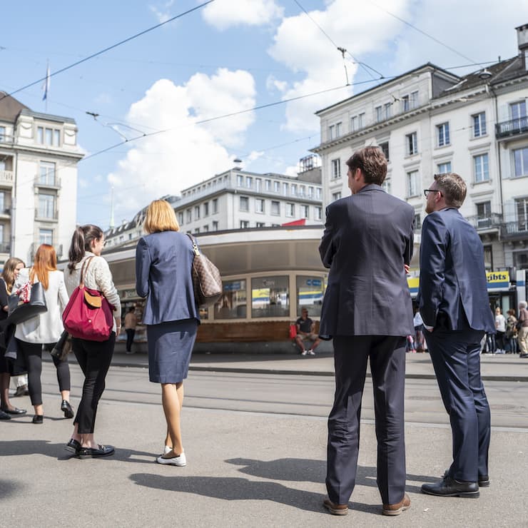 Passanten warten an der Tramstation am Zuercher Paradeplatz, am Mittwoch, 9. Mai 2018, in Zuerich. (KEYSTONE/Patrick Huerlimann)