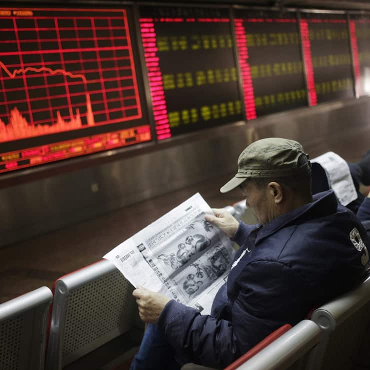 epa05087380 Chinese investors read newspapers in front of a screen showing stock movements at a stock brokerage house in Beijing, China, 04 January 2016. Shares plunged across Asia and trading was halted on the Chinese markets 04 January on a miserable start to 2016 for investors in the region. Trading on China's main bourses, the Shanghai and Shenzhen stock exchanges, halted for the day as a benchmark index fell over 7 per cent off the back of weak Chinese manufacturing data.  EPA/HOW HWEE YOUNG