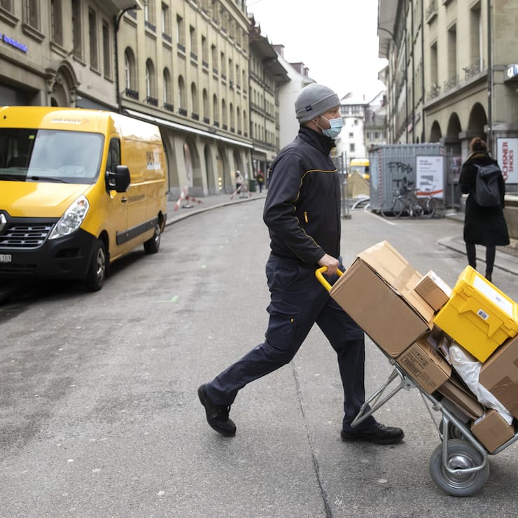 Ein Paketbote der Post liefert Pakete aus, am Donnerstag, 11. Februar 2021, in Bern. (KEYSTONE/Peter Klaunzer)