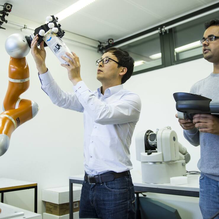 Seungsu Kim, et Ashwini Shukla, chercheurs, presentent un bras robotique ultra-rapide qui saisit des objets en plein vol developpe par le Laboratoire d'algorithmes et systemes d'apprentissage (LASA) de l'EPFL ce lundi 12 mai 2014 sur le site de l'EPFL a Lausanne. (KEYSTONE/Jean-Christophe Bott)