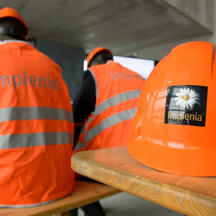 Ein Helm mit dem Implenia Logo 
