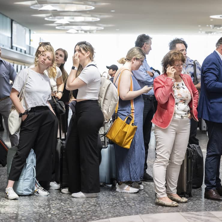 Fluggaeste warten vor einer Anzeigetafel am Mittwoch, 15. Juni 2022, auf dem Flughafen in Zuerich. Wegen einer Informatikpanne von Skyguide sind die Flughaefen Zuerich und Genf derzeit lahmgelegt. Es koennen weder Flugzeuge starten noch landen, wie eine Sprecherin in Zuerich auf Anfrage sagte. Auch Ueberfluege ueber die Schweiz sind nicht moeglich. (KEYSTONE/Ennio Leanza).
