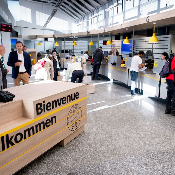 Une cliente parle au guichet d'une Poste avant une conference de presse de La Poste, sur le bilan intermediaire de sa strategie de transformation et de restructuration de son reseau 2020 ce lundi 15 octobre 2018 a Fribourg. (KEYSTONE/Laurent Gillieron)