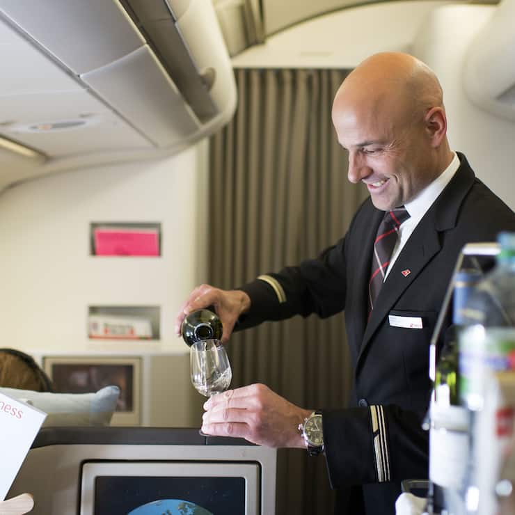 A flight attendant attends to the Business Class passengers, pictured on April 29, 2013 in an aircraft of Swiss. Swiss, short for Swiss International Air Lines, flies from Zurich to Chicago and back. (KEYSTONE/Christian Beutler)Ein Flugbegleiter bedient die Passagiere der Business Class, aufgenommen am 29. April 2013 in einem Flugzeug der Swiss. Die Schweizer Fluggesellschaft Swiss fliegt von Zuerich nach Chicago und zurueck. (KEYSTONE/Christian Beutler)
