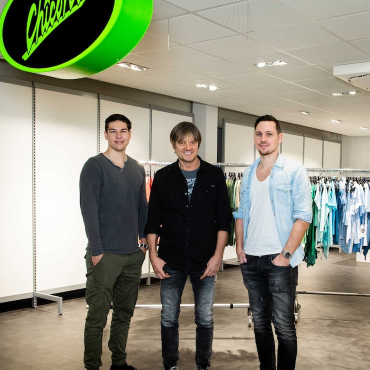 Mathias (l.) und Pascal (r.) sowie Thomas Ullmann (M.) vor einem Chicorée-Store.