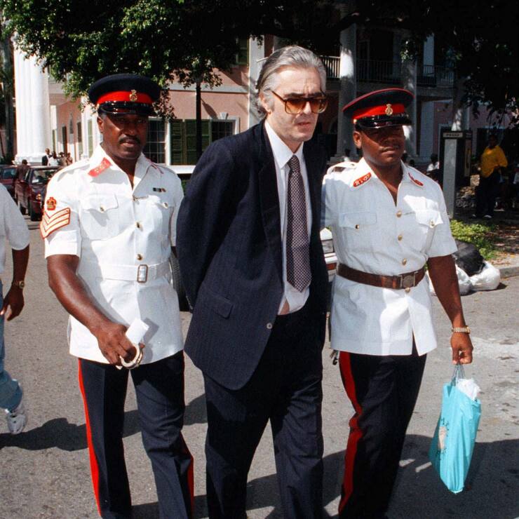 Der an Haenden und Fuessen zusammengekettete Schweizer Financier Werner K. Rey (Mitte) wird am Montag, 23. Juni 1997, von Polizisten zum Obergericht von Nassau, Bahamas, geleitet. Am 16. Maerz 1998 begann vor dem Privy Council, dem obersten Gericht des Commonwealth, in London der Prozess um die Auslieferung von Rey an die Schweiz. Bei einer Bestaetigung durch die vierte Instanz wuerde der Financier Werner K. Rey noch im laufenden Jahr an die Schweiz ueberstellt. (KEYSTONE/Craig Lenihan)