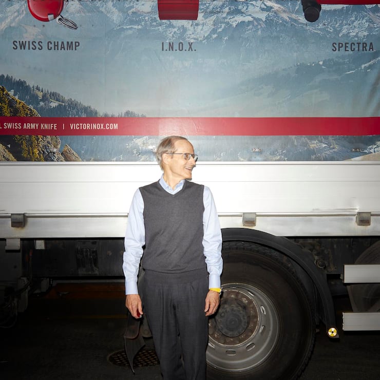 Carl Elsener vor einem Lastwagen blickt nach rechts.