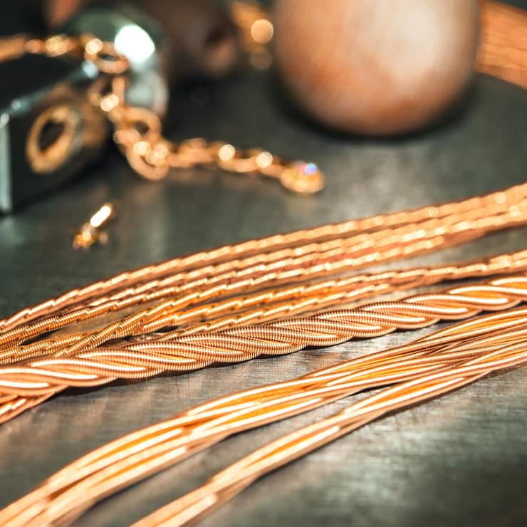 Produktfotografie von Goldkordeln auf schwarzem Untergrund aus der Goldschmiede Wellendorff.