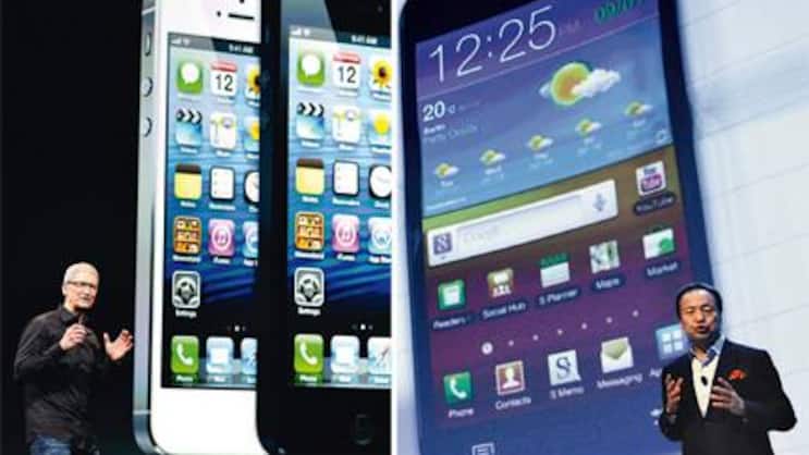 iPhone versus Galaxy: Apple-Chef Tim Cook (l.) und JK Shin, Mobilfunk-Chef von Samsung.