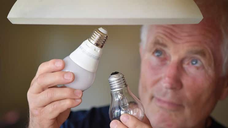 Eine Halogenlampe (r.) wird gegen eine energiesparende LED-Lampe ausgewechselt.