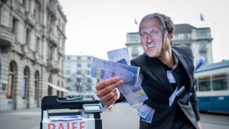 Ein Vollgeld-Aktivist mit einer Pierin Vincenz-Maske hält gedruckte Tausender Noten in der Hand.