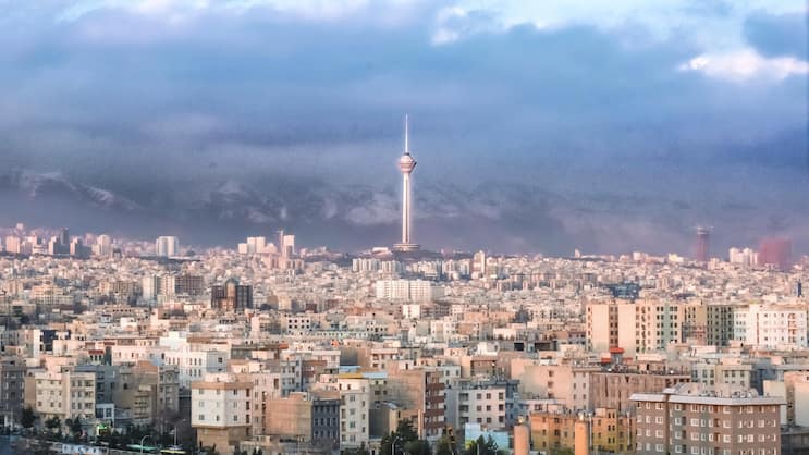 Tehran urban "skyline" with prominent "Milad tower" and air pollution hiding the "Alborz" mountain range ("Mount Tochal") in Tehran, Iran