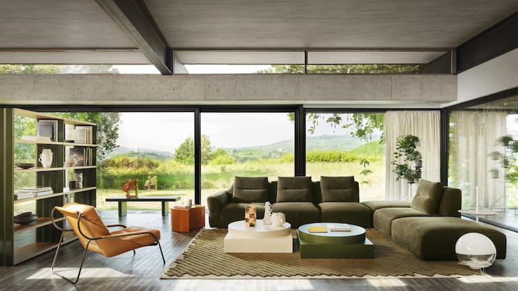 Auf einem handgeknüpften Teppich präsentieren sich ein modulares Sofa und formstarke Couchtische. Das Regal verbindet Wohnlichkeit und Durchsicht. www.zanotta.com