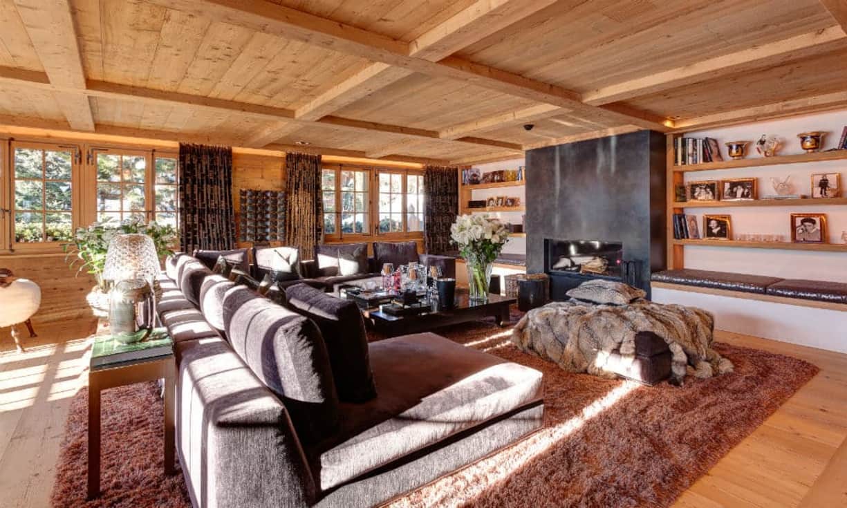 Das Wohnzimmer mit Cheminée, hat Zugang zum grosszügigen Balkon mit unglaublicher Aussicht auf die Saanenländer-Berge.