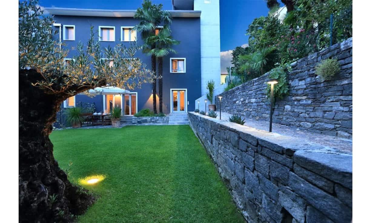 Der pflegeleichte Garten mit Rasen, Palmen und Olivenbaum umfasst rund 456 m² und wird auf der einen Seite durch eine Natursteinmauer vom Nachbarsgrundstück getrennt.