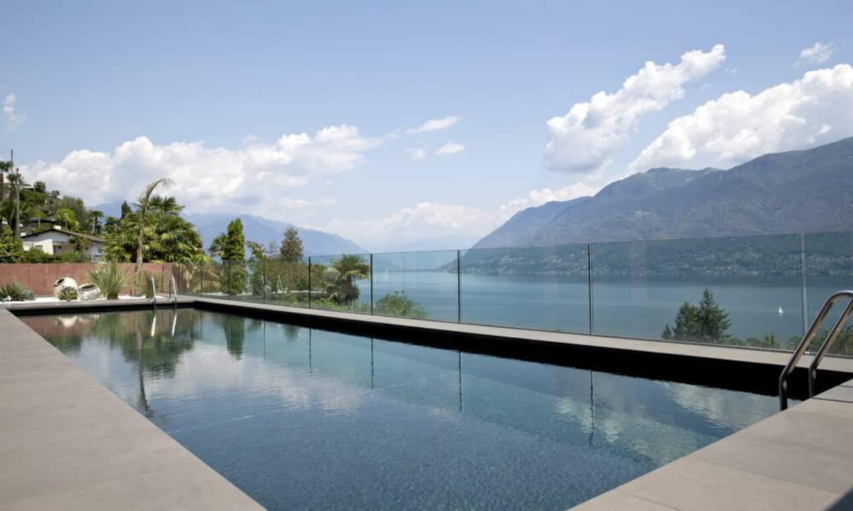 Aus dem Aussenpool geniesst man eine atemberaubende Sicht auf den See und das umliegende Bergpanorama.
