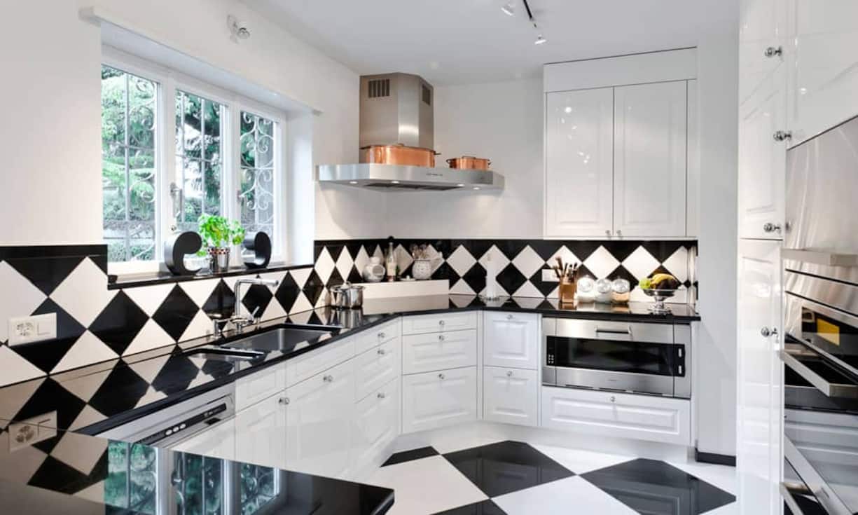 Die geschlossene Küche mit hochglanzweissen Fronten und schwarzer Granitarbeitsfläche bietet hochwertigen Ausbaustandard und viel Stauraum.