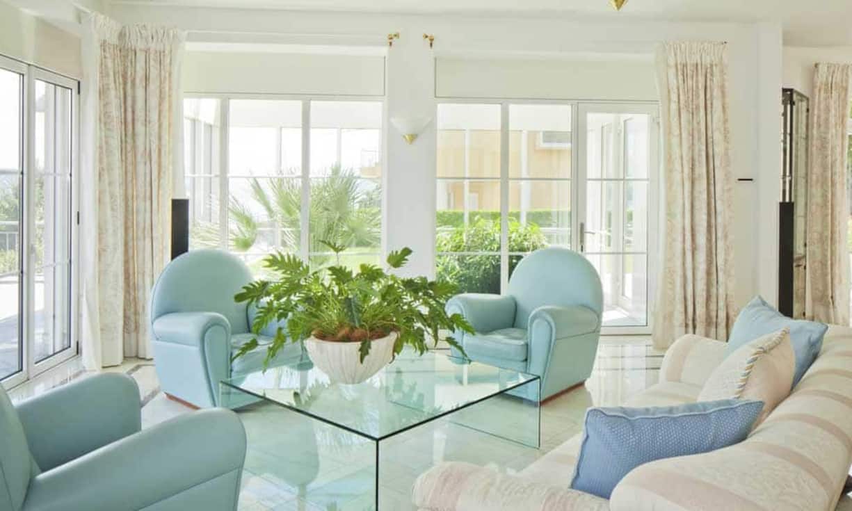 Über ein Eingangsportal gelangt man in die grossen Räume des Hauses. Das seitlich angelegte Treppenhaus ist mit farbigen Tiffanyfenstern ausgestattet und erschliesst die zwei Wohnebenen. Im offenen Wohnzimmer mit Essbereich und angrenzender Bibliothek, welche durch ein zweiseitig einsehbares Cheminée getrennt wird, kann man mit Seesicht entspannen.