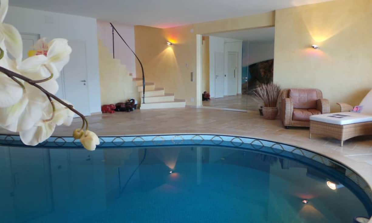 Ein Highlight: Der Poolbereich mit Naturfels. Die grosse offene Dusche, eine moderne Sauna sowie ein WC gehören zum Wellnessbereich.