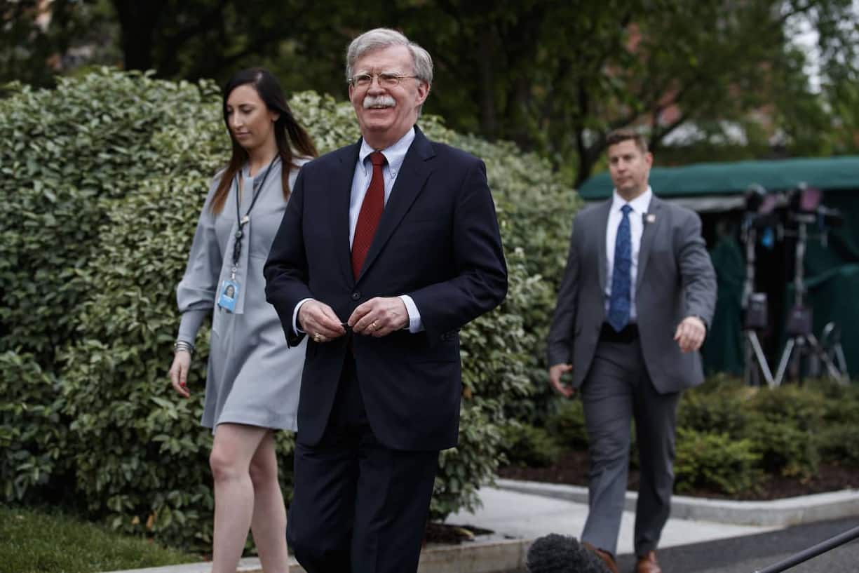 National security adviser John Bolton walks over to speak with reporters about Venezuela, outside the White House, Wednesday, May 1, 2019, in Washington. (AP Photo/Evan Vucci)
