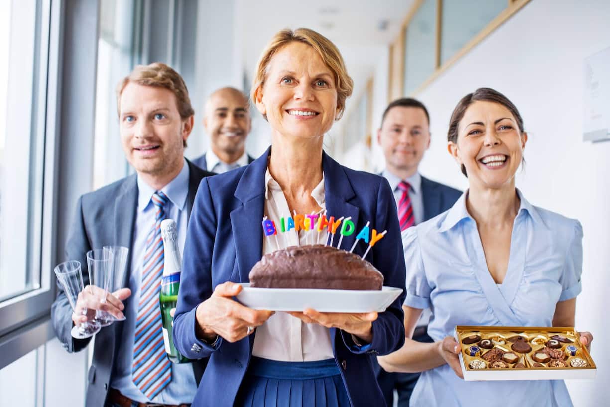 Happy group of business people celebrating birthday in office