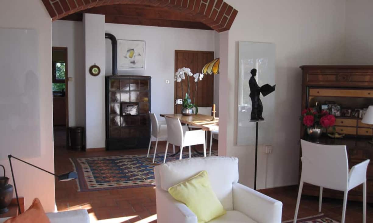 Beide Häuser heizen mit elektrischen Heizkörpern. Im Haupthaus kann mit dem Ölofen zusätzlich das Wohn- und Esszimmer beheizt werden.