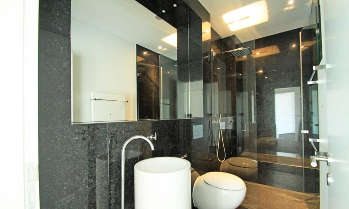 Master-Bad mit Regendusche, freistehender Badewanne und Installationen von Alessi.