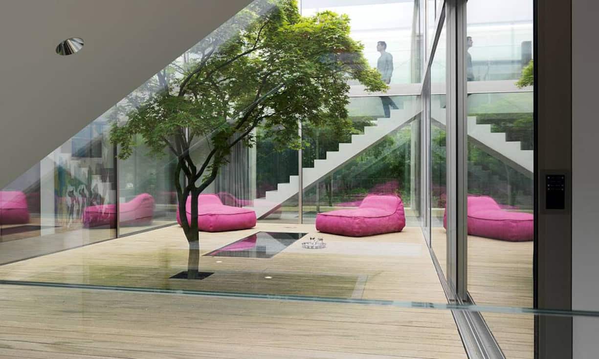 Akzentuiert: Die rosaroten Loungekissen bringen starke Farbakzente in den Lichthof, der in der Übergangszeit rege genutzt wird.