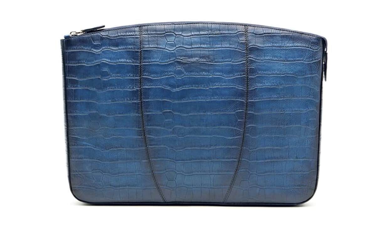 Santoni Ordentlich: Diese College-Mappe des italienischen Luxusschuh-Herstellers Santoni mit markanter Krokoprägung ist eine modische Variante, um Dokumente zu transportieren. Sie wird unter dem Arm getragen und ist von Hand in Blautönen gefärbt und poliert. Preis: 625 Franken