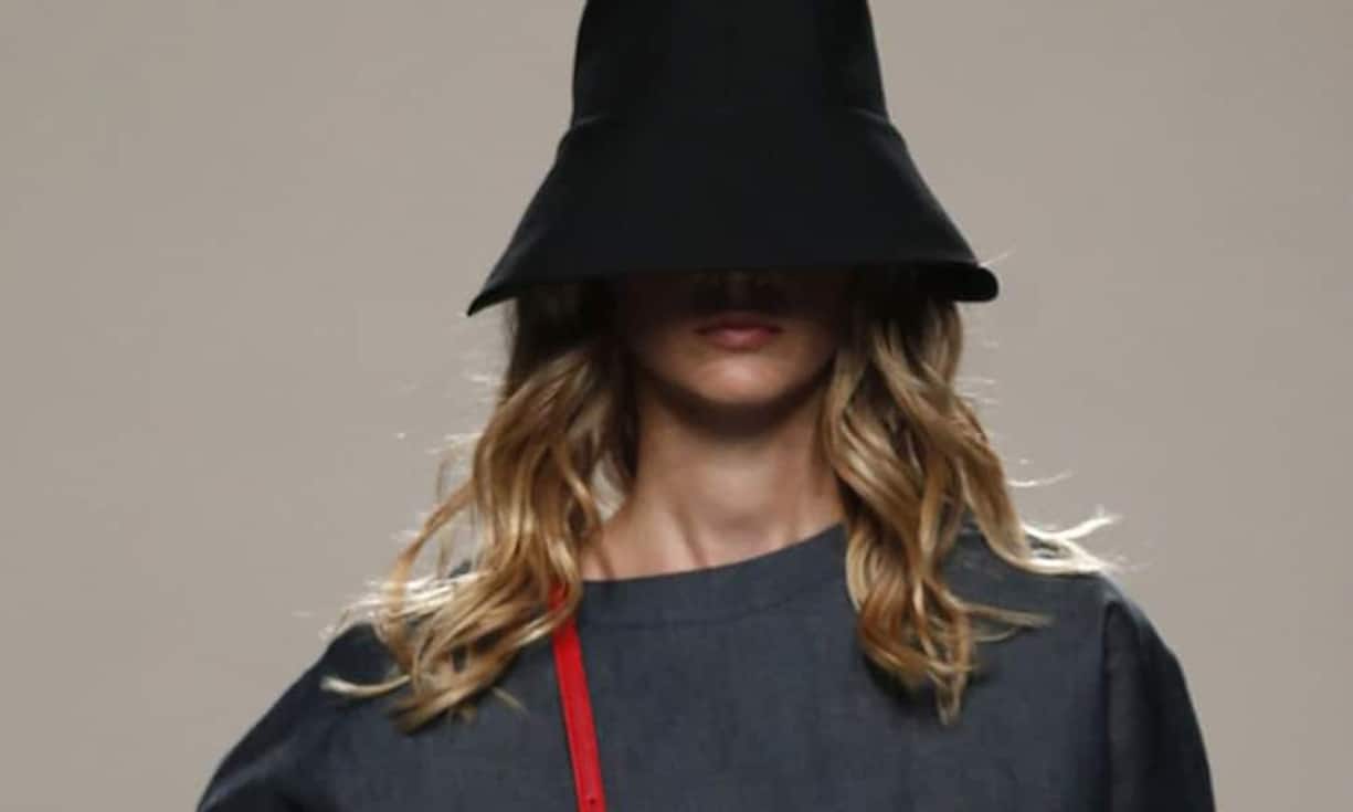 Madrid, Spanien (September 2013): Zensur - die spanische Designerin Juanjo Oliva setzt dem Model einen Hut ins Gesicht.