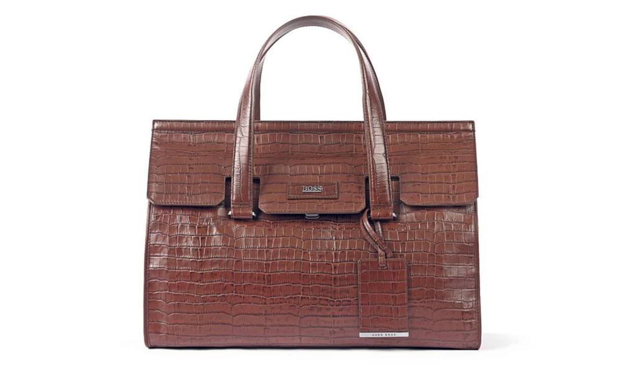 Boss - ElegantDiese braune Business-Tasche aus geprägtem Kalbsleder trägt das Boss-Logo auf der Vorderseite und hält diverse Innenfächer für Computer, Telefon und Unterlagen bereit. Preis 999 Franken