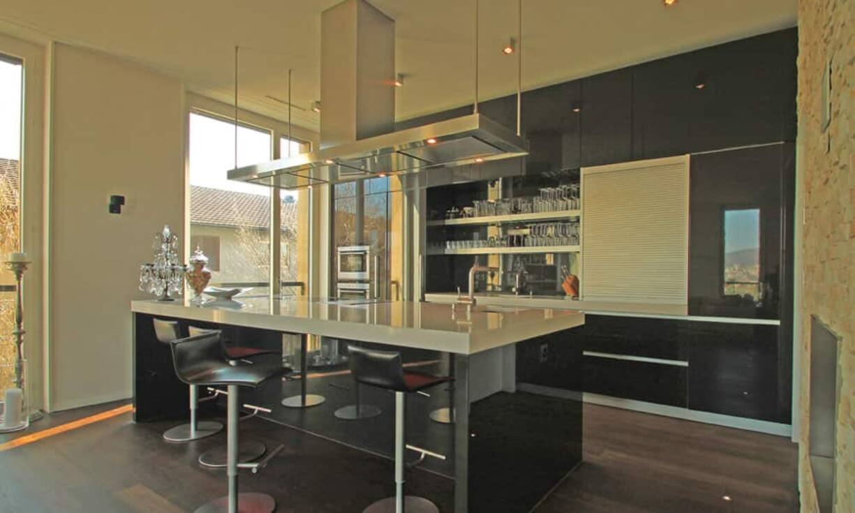 Eine italienische Varenna-Küche mit dunklen Hochglanzfronten und Ess-Theke sowie Teppanyaki Feld und Steamer bietet alles, um sich kulinarisch zu verwirklichen.