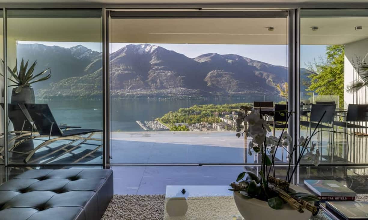 In der Attikawohnung verteilen sich 3,5 Zimmer auf einer Wohnfläche von 190 Quadratmetern. Vom Wohnzimmer aus mit bedeckter Terrasse blickt man direkt auf den Lago Maggiore und die umliegenden Berge.